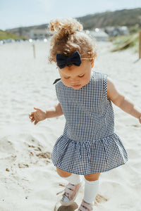 Gingham matching peplum top and bloomers in navy. Summer clothing for girls aged 0-2 years. Cotton summer outfits with a ribbon tie at the bak.