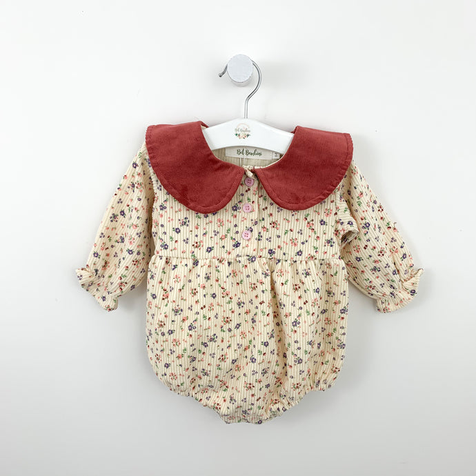 Girls romper suit in a ditsy floral print wiuth a peter pan statemnet style collar. Available for girls aged 0-24 months. Exclusive in Bel Bambini baby girls collection for spring.