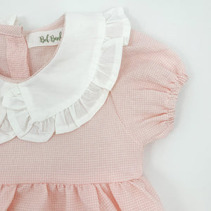 Detail shot of our girls pink romper showing the elasticated cuff on the sleeve hem and the pretty frill collar.