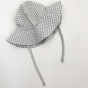 Matching floppy hat for our baby boys romper set. Plaid print in white and black together with a matching romper and a gingham printed shirt. 0-24 month clothing and accessories at Bel Bambini baby boutique.