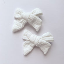 Load image into Gallery viewer, White bow hair clips for girls made in a soft cotton linen fabric, matched perfectly to our girls collection outfits. Exclusive to Bel Bambini baby and toddler boutique. Available in a variety of colours and perefect for pig tails, hair up doos, hair down or just to clip hair back to the side.