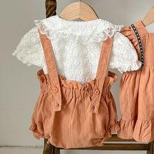 Load image into Gallery viewer, Back detail shot showing the lace trim collar on the embroidered blouse and the back of the bloomer dungarees with two button fastenings for the straps. Sets for baby and toddlers. Free shipping over £60 spend.