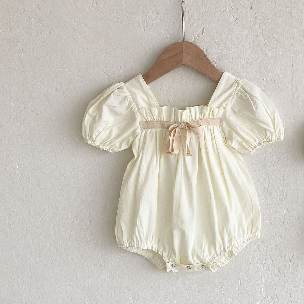 Beautiful white romper with a contrasting bow in a soft pink shade, gathering throughout the squared neckline and stylish puff sleeves. Perfect for family gatherings, special occasions and holiday outfits. Girls clothing from our stunning collections are available from our UK based online store.