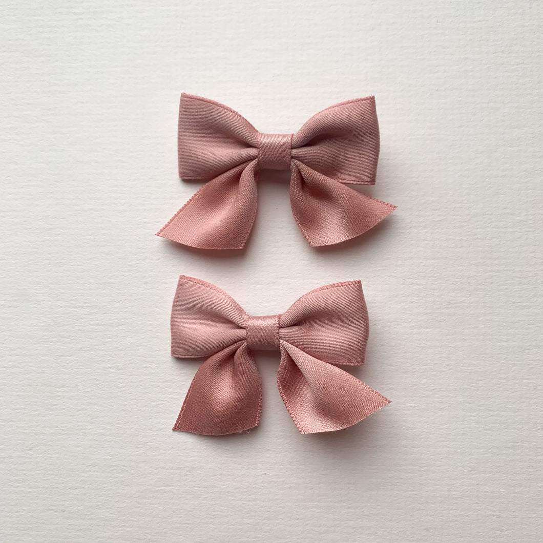 Pink satin hair clips for girls, perfect hair accessories for pigtails and cute hairstyles. Available in a red satin also exclusive to Bel Bambini baby boutique.