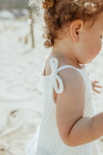 Load image into Gallery viewer, Bow ties to the shoulders on our delicately knitted romper in white. Perfect outfit to wear alone or to layer up when its cold. Baby girl clothing up to 2 year old.