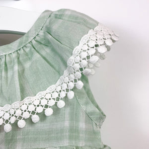Detail of the crochet neckline. Beautiful summer rompers and outfits at Bel Bambini baby boutique.