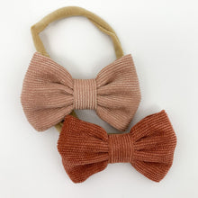 Load image into Gallery viewer, Corduroy bow headbands for baby girls, available in a variety of colours. This pack has peach and rust colours in, with a super soft and stretchy headband. Perfect to style your little ones Bel Bambini outfits with whilst looking adorably cute too. Exclusive girls headbands  at Bel Bambini baby boutique.