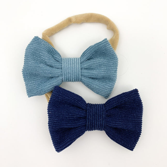 Two pack of headbands for girls. Super soft and stretchy band and a pretty corduroy bow. Blue and midnight coloured headbands for baby girls and toddler girls. Girls bow headbands available in a variety of colours exclusive to Bel Bambini baby boutique.