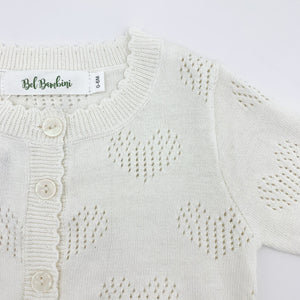 Scallop edging and heart detailing make this baby girls knitted cardigan such a sweet piece to finish off any outfit. Made from cottn yar, soft and comfortable for girls ages 0-24 months. Shop our baby and toddler clothing at Bel Bambini baby boutique.