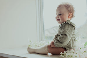 Spring summer clothing for your baby and toddlers. Baby girl wearing our flutter detail romper in sage green.