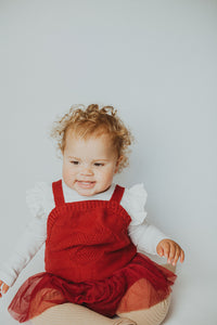 Girls romper in red with a mesh skirt. Knitted with a heart detail to the front chest. Christmas romper in red is perfect for 0-24months girls.