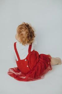 Back detail shot of our christmas red romper for baby girls and toddlers 0-24 months. Layer with one of our cute long sleeve tops and ribbed tights to complete the look.