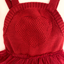 Load image into Gallery viewer, Detail shot of the knitted heart featured on our red knitted romper for baby and toddler girls, 0-2 years. Christmas romper in red for girls is warm, soft and comfortable.