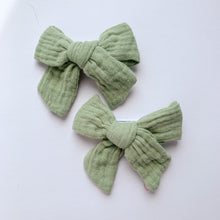 Load image into Gallery viewer, Sage Green bow hair clips for girls made in a soft cotton linen fabric, matched perfectly to our girls collection outfits. Exclusive to Bel Bambini baby and toddler boutique.
