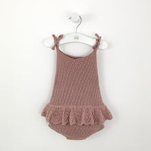 Load image into Gallery viewer, baby girls knitted romper in dusty pink with a scalloped frill arounf the hip to make it extra pretty. Shoulder ties into a bow and button fastenings to the bottom. Beautiful baby and toddler clothing at Bel Bambini.