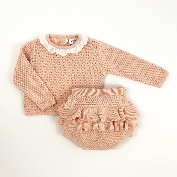baby and toddler cute knitted set in soft shell pink. Adorable bloomers and knitted top for girls. Top has a pretty contrast frill to the neck in white and button fastenings down the back. Long sleeves. Stunning baby girl outfit.