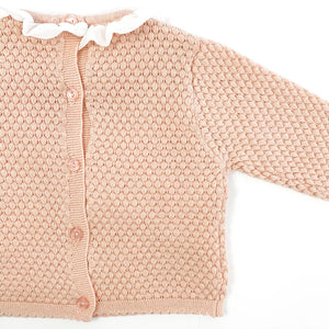 Detail shot of our Bel Bambini two piece knitted set in shell pink. Stunning girls knitted outfit. button fastenings doen tge centre back and a frill collar, such a beautiful baby set. 0-24 months baby clothing and toddler styles.