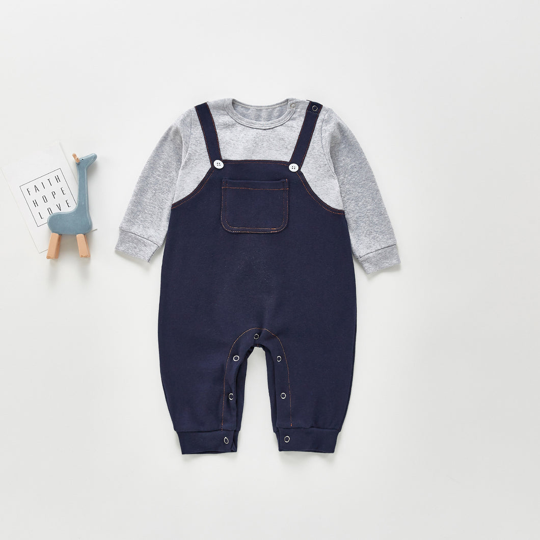Boys all in one dungaree romper. Popper fastenings to the crotch for easy nappy changes. Long sleeve contrast grey tee and denim style dungarees that make this cute little omne piece look like two seperate pieces. Pocket detail to the front and button fastenings to the straps. Two popper fastenings to the left shoulder.