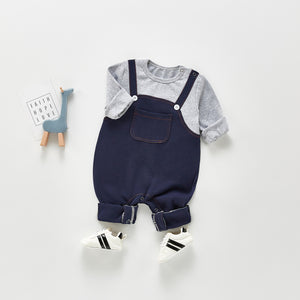 Baby and toddler boys dungaree romper. Popper fastenings and button dtails to the straps. Pocket to the centre front. Available in grey and denim.