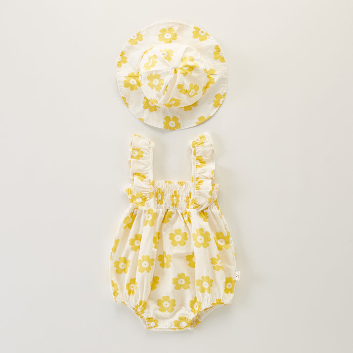 Yellow flower printed romper and hat set for baby girls aged up to 18 months. Perfect for summertime with the lightweight cotton fabrication. Frilly straps and ruched detailing are perfectly stylish for baby girls and super cute together with the matching floppy hat. Shop our girls collections online at Bel Bambini baby boutique.