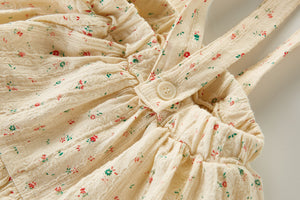 Green and red floral print on a delicate textured fabric base in latte. Timeless styles for baby girls and toddlers.