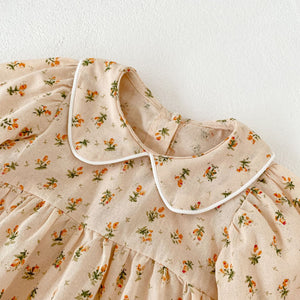 Peter pan collar with white contrast biding on our neutral floral print baby romper for girls 0-2 years.
